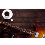 guitar laying on a table with cable