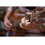 man playing an acoustic guitar with chords